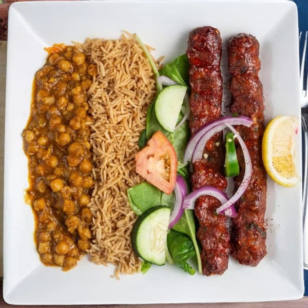 Mehran Restaurant's Pakistani dish with chickpea curry, rice, three seekh kebabs, and a side salad.